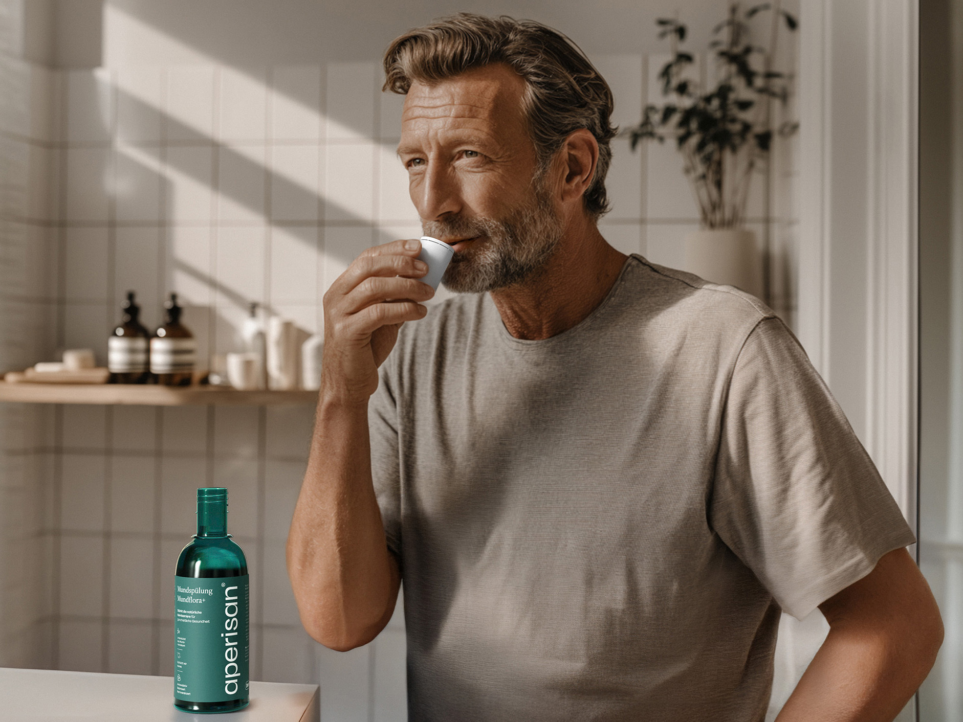 Mann verwendet Aperisan Mundspülung Mundflora+