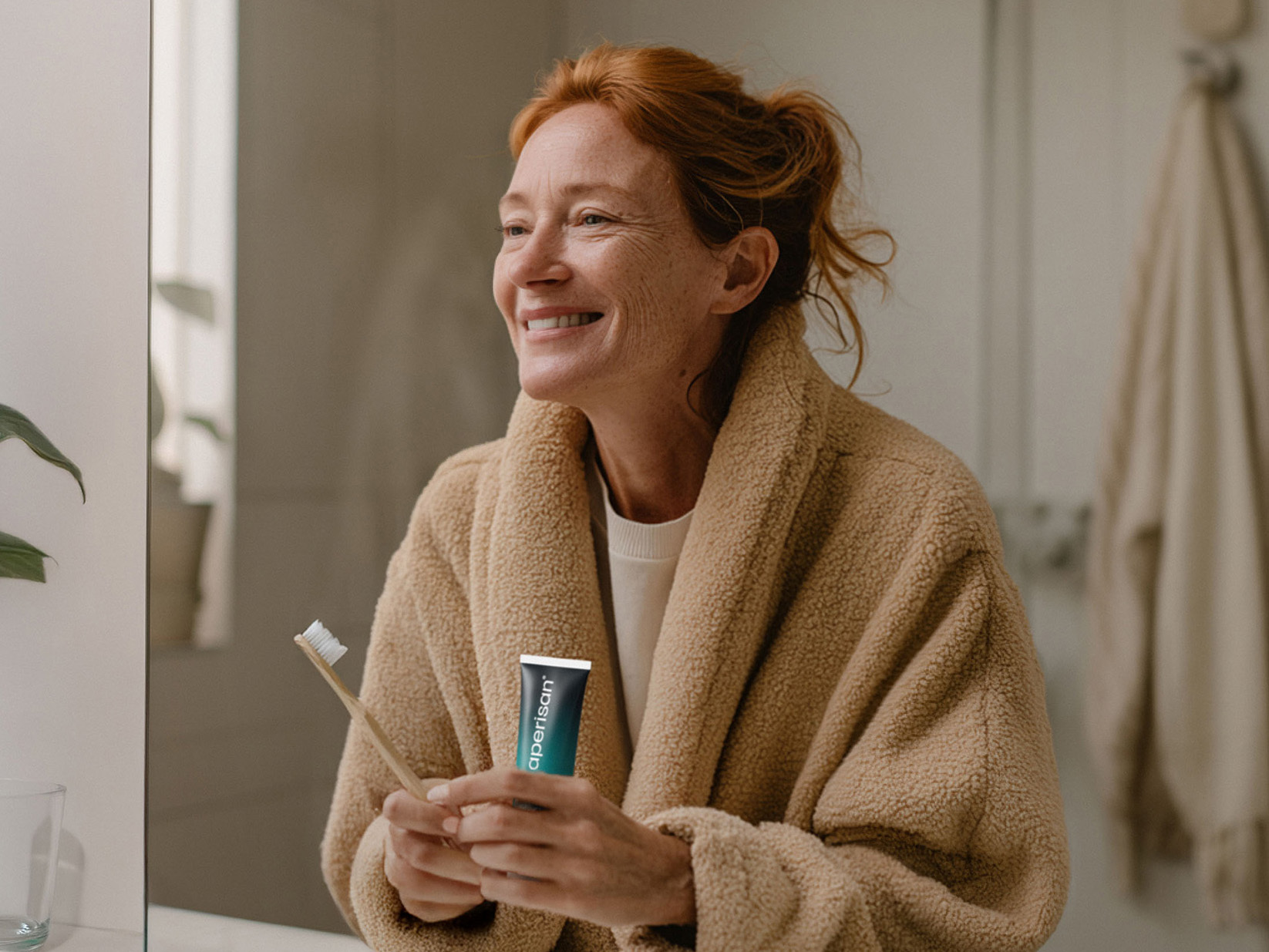 Frau beim Zähneputzen mit Aperisan Zahncreme Mundflora+